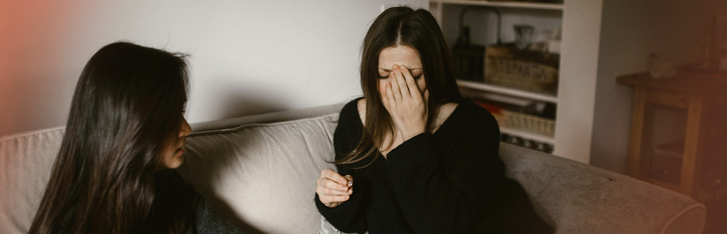 Distressed woman on couch, showing emotional symptoms of perimenopause and hormone shifts