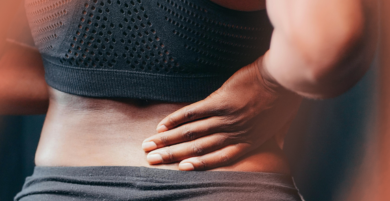 Person holding their lower back in discomfort