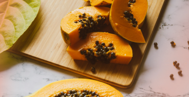 Pile of ripe pineapples with green leaves at market