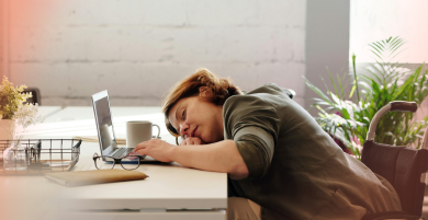 Sleeping through PMS challenges visualized by a tired woman resting on her laptop