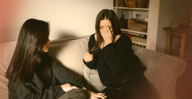 Distressed woman on couch, showing emotional symptoms of perimenopause and hormone shifts